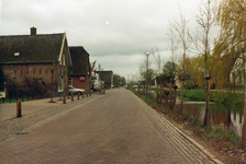 847738 Gezicht over de weg Dorp in Benschop vanuit de auto, na de herinrichting van de weg; rechts de Benschopper Wetering.